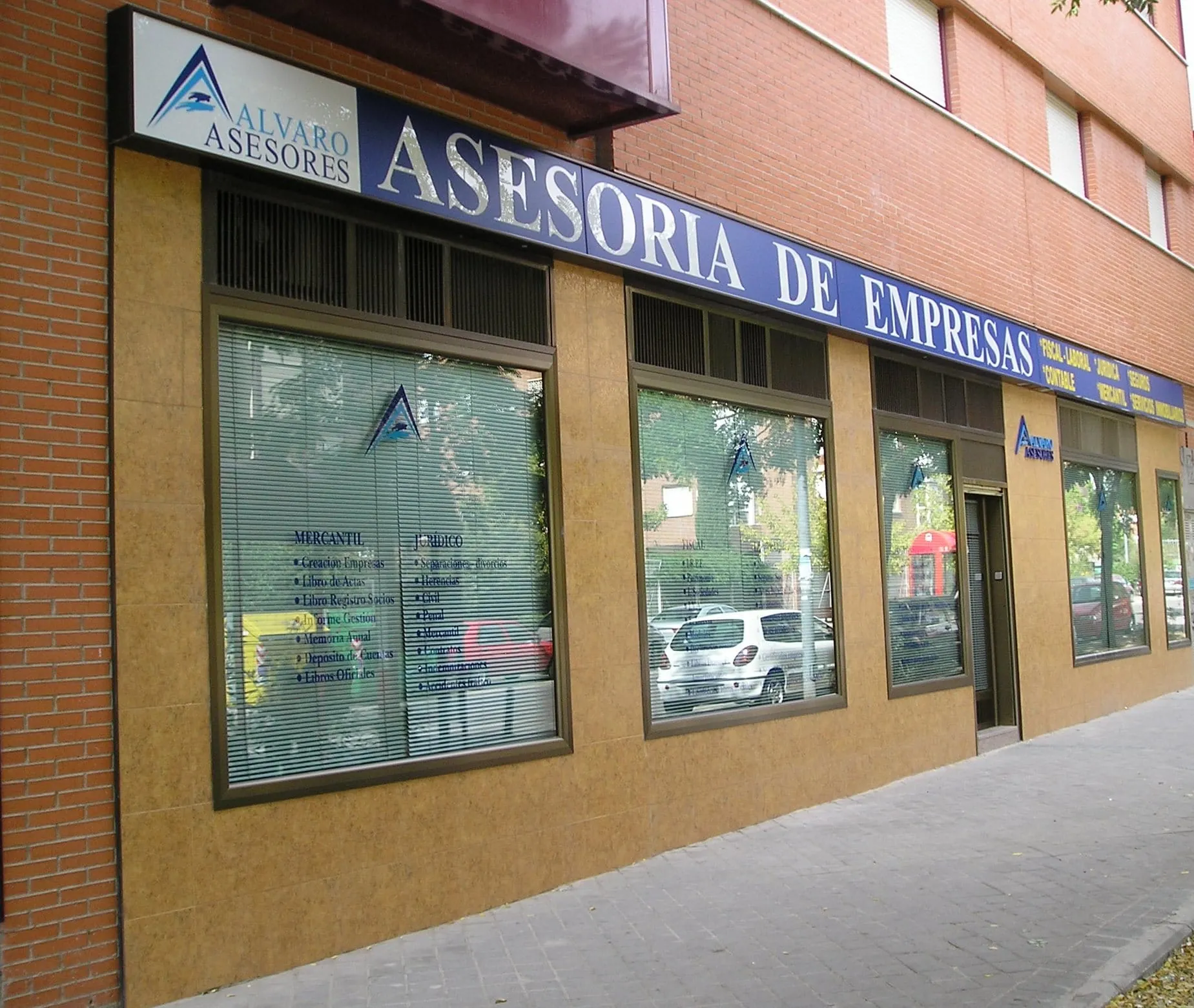 Fachada de la oficina de Álvaro Asesores en Torrejón de Ardoz, con el rótulo de asesoría de empresas sobre los escaparates